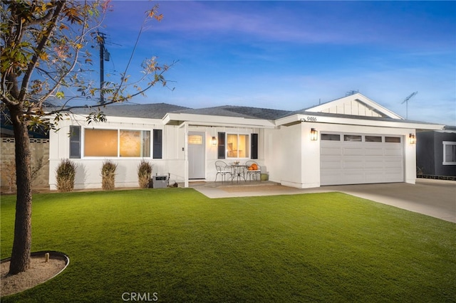 view of front facade with a garage, a front yard, and a patio area