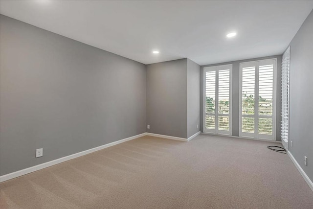 unfurnished room featuring light carpet