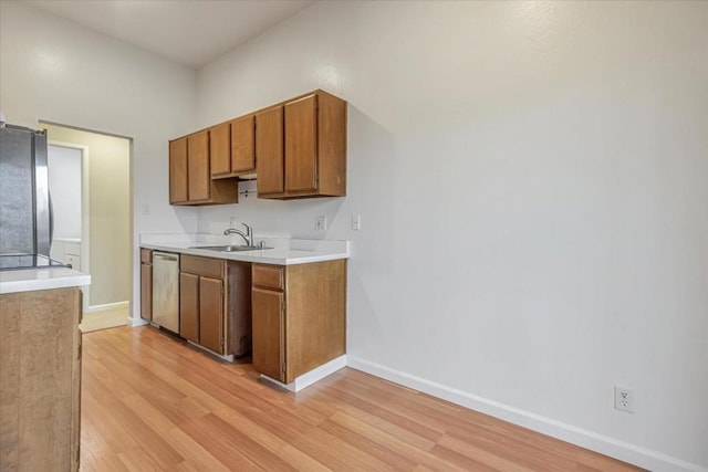 kitchen featuring appliances with stainless steel finishes, sink, and light hardwood / wood-style floors