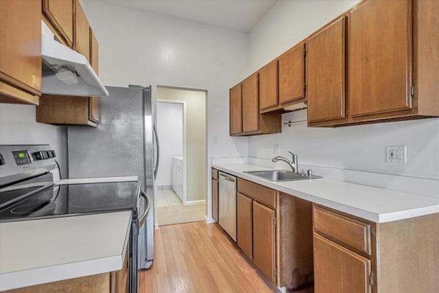 kitchen with sink, stainless steel appliances, and light hardwood / wood-style floors