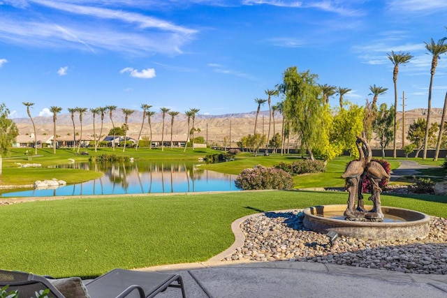 surrounding community featuring a water and mountain view and a yard