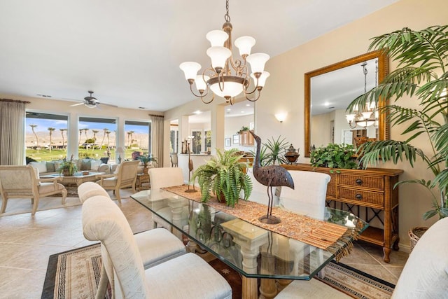 dining area featuring light tile patterned flooring and ceiling fan with notable chandelier