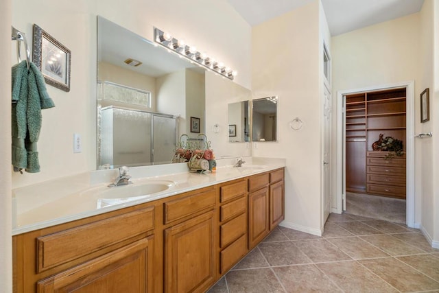 bathroom with tile patterned flooring, a shower with shower door, and vanity