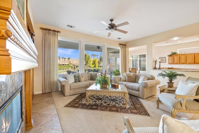 tiled living room with ceiling fan and a tiled fireplace