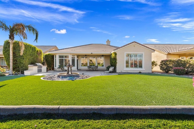 rear view of property with exterior kitchen, a patio area, and a yard