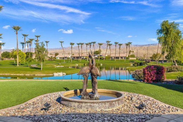 surrounding community featuring a water and mountain view and a yard