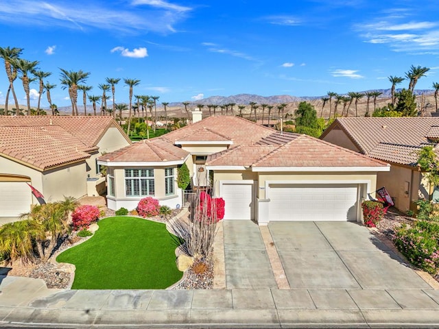 view of front facade with a mountain view, a front lawn, and a garage