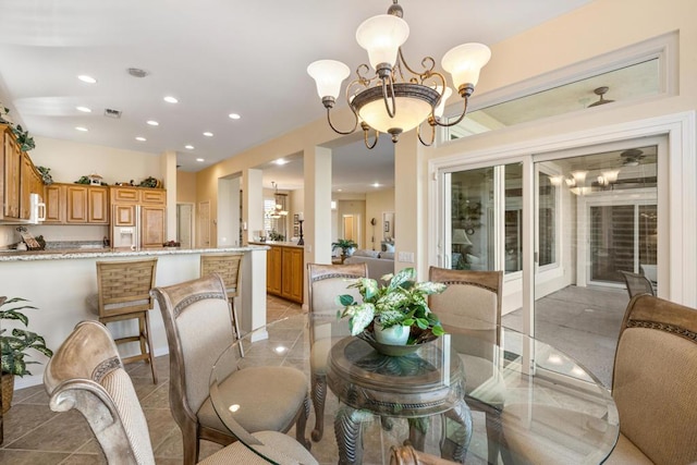 dining area featuring light tile patterned floors and a notable chandelier