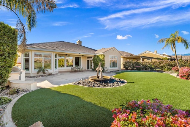 back of house with a yard and a patio