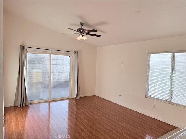 empty room featuring ceiling fan, a healthy amount of sunlight, and hardwood / wood-style floors