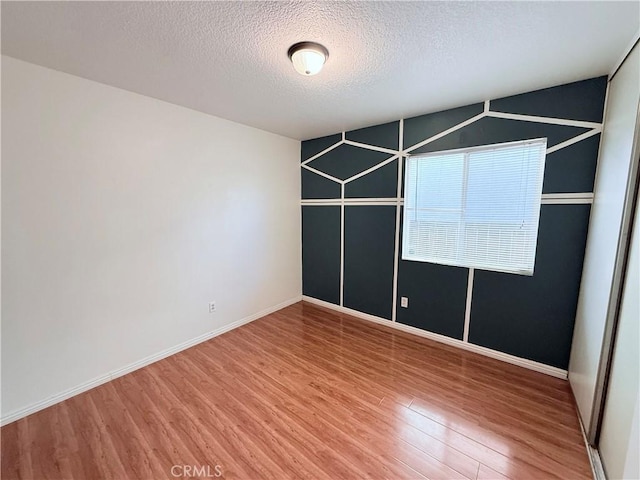 spare room featuring a textured ceiling and hardwood / wood-style floors