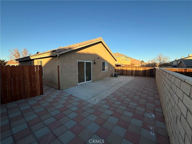 back of house with a patio area and central AC