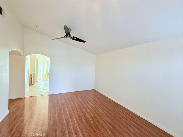 spare room featuring vaulted ceiling, ceiling fan, and light hardwood / wood-style floors