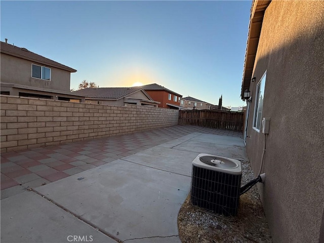 patio terrace at dusk featuring cooling unit