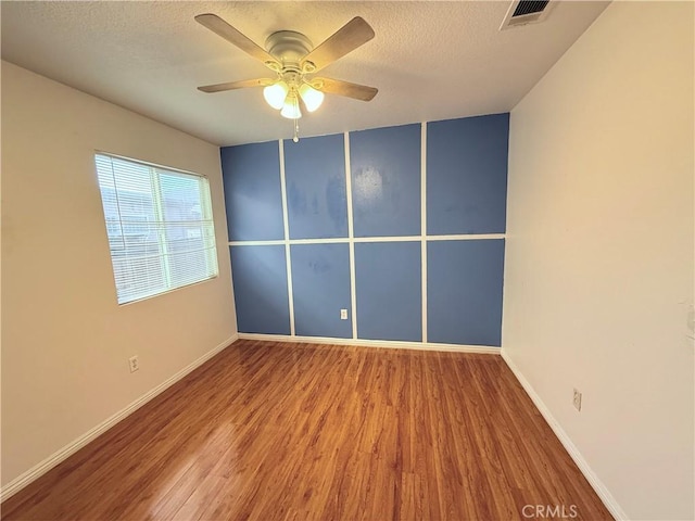 spare room with a textured ceiling, ceiling fan, and hardwood / wood-style flooring