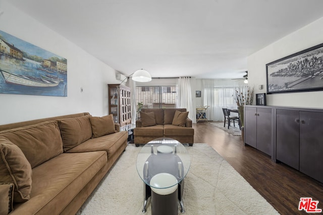 living room with ceiling fan and dark wood-type flooring