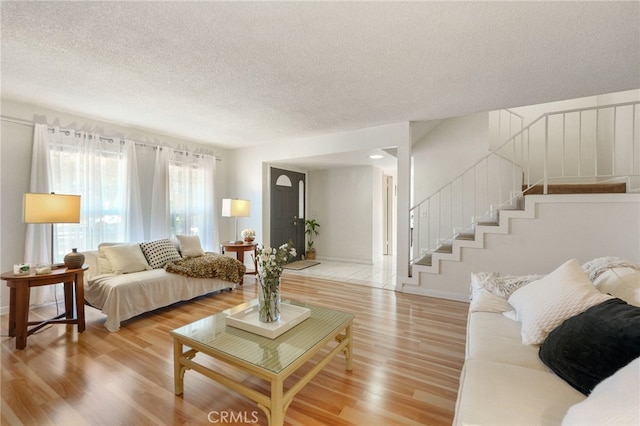 living room with a textured ceiling and light hardwood / wood-style flooring