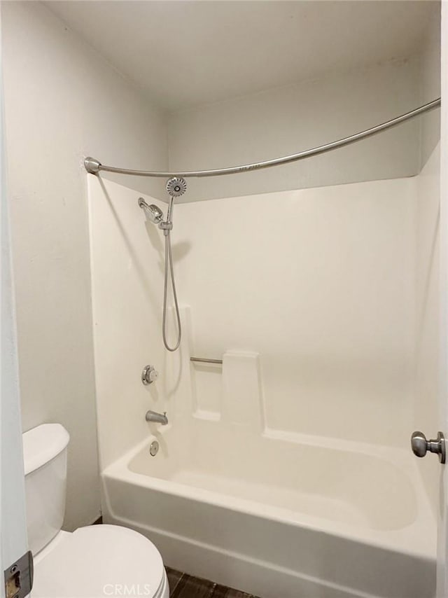 bathroom featuring hardwood / wood-style flooring, tub / shower combination, and toilet