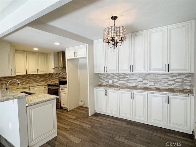 kitchen with stainless steel electric stove, pendant lighting, white cabinets, and wall chimney exhaust hood