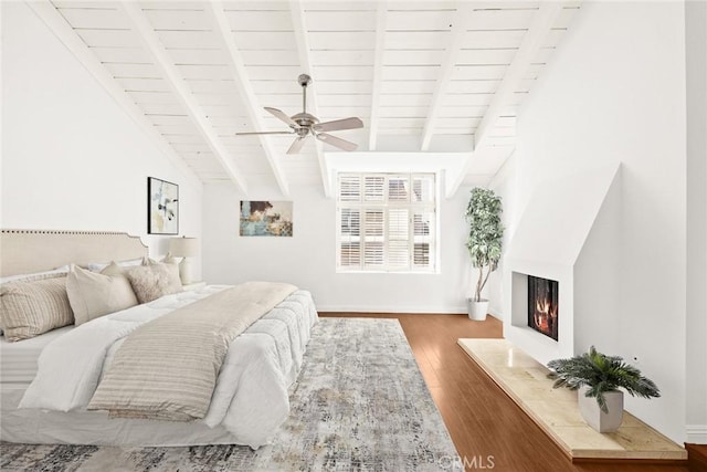 bedroom with dark wood-type flooring, ceiling fan, vaulted ceiling with beams, and wooden ceiling