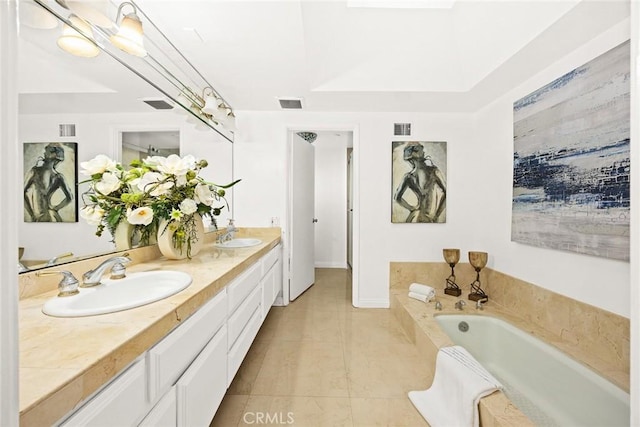 bathroom with tiled bath, vanity, and tile patterned flooring