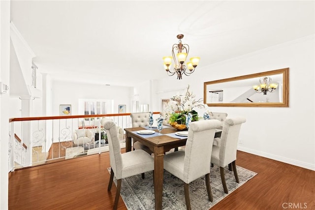 dining area with hardwood / wood-style floors and a notable chandelier