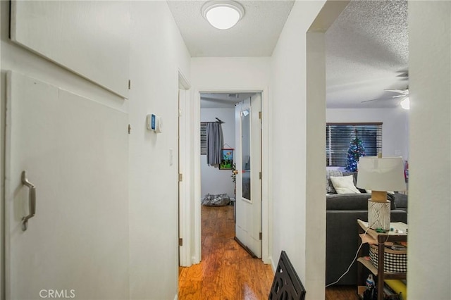 hallway featuring a textured ceiling and hardwood / wood-style floors