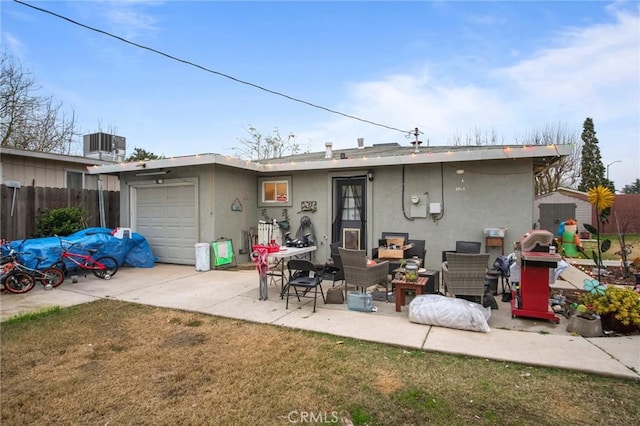 back of house with a patio area, central air condition unit, a garage, and a yard