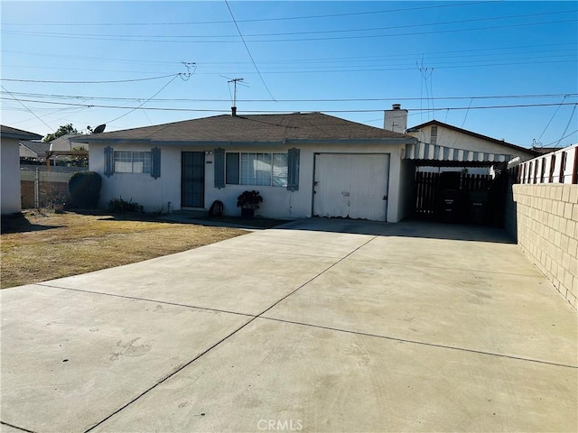 ranch-style home with fence, concrete driveway, and stucco siding