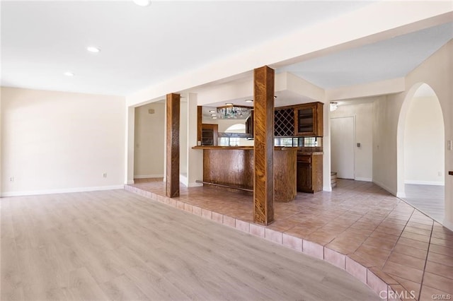 unfurnished living room featuring light wood-type flooring and indoor bar