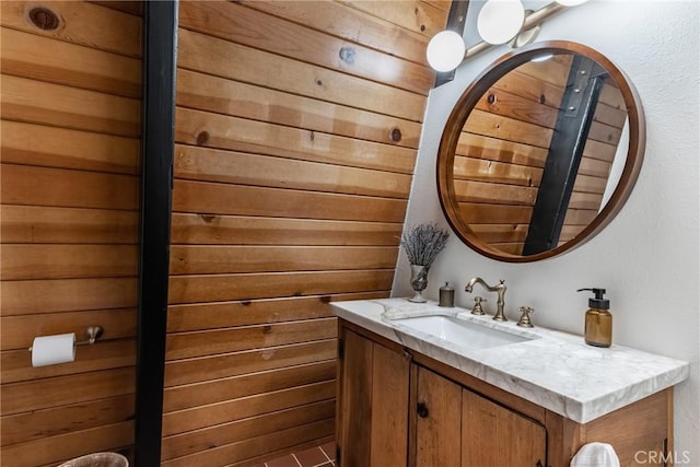 bathroom featuring vanity and wood walls