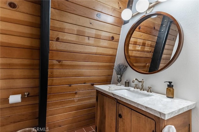 bathroom featuring vanity and wooden walls