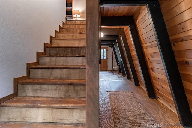 stairs featuring wood walls and a textured wall