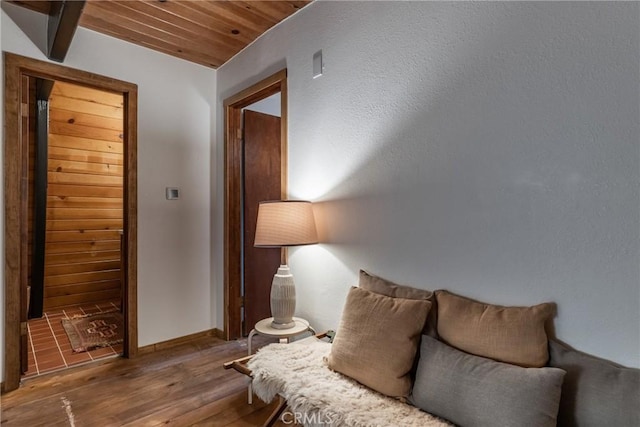 living area featuring visible vents, baseboards, wood finished floors, and wooden ceiling