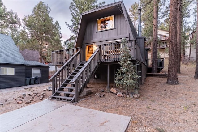 rear view of house featuring a deck and stairway