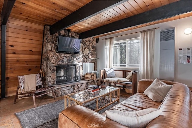 living room with wood ceiling, beam ceiling, and a stone fireplace