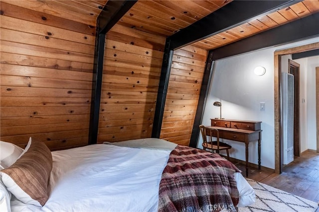 bedroom with beamed ceiling, hardwood / wood-style flooring, and wooden ceiling