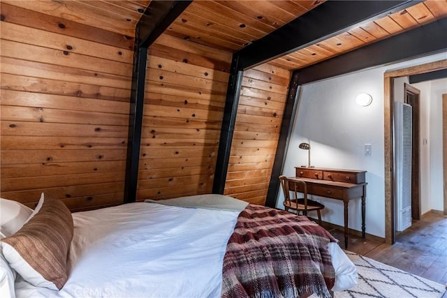 bedroom featuring beamed ceiling, wooden ceiling, baseboards, and wood finished floors