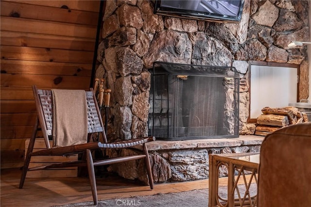 interior details featuring wood walls, a fireplace, and wood finished floors