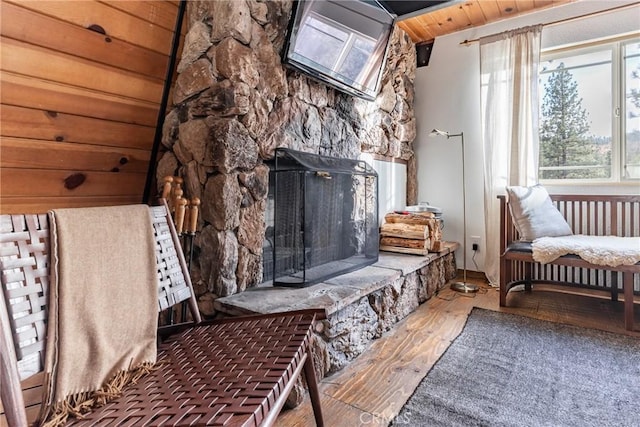 living area with hardwood / wood-style flooring, a fireplace, and wooden ceiling