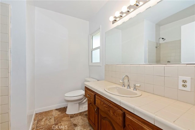 bathroom with tasteful backsplash, vanity, a shower, and toilet