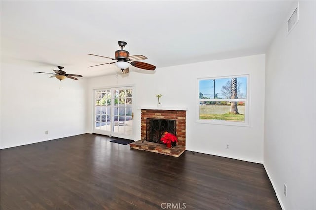 unfurnished living room with ceiling fan, a fireplace, and dark hardwood / wood-style flooring