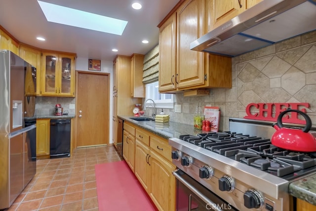 kitchen with backsplash, sink, light tile patterned flooring, a skylight, and appliances with stainless steel finishes