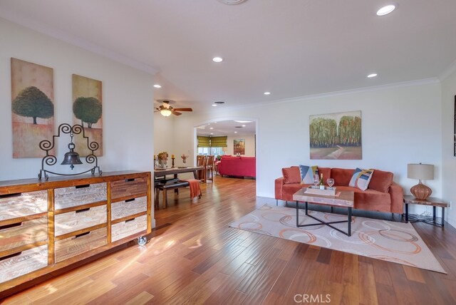 living room with crown molding, ceiling fan, and hardwood / wood-style flooring