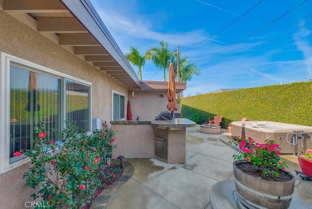 view of patio featuring a hot tub, a fire pit, and area for grilling