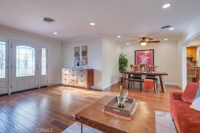 living room with ceiling fan, crown molding, and light hardwood / wood-style flooring