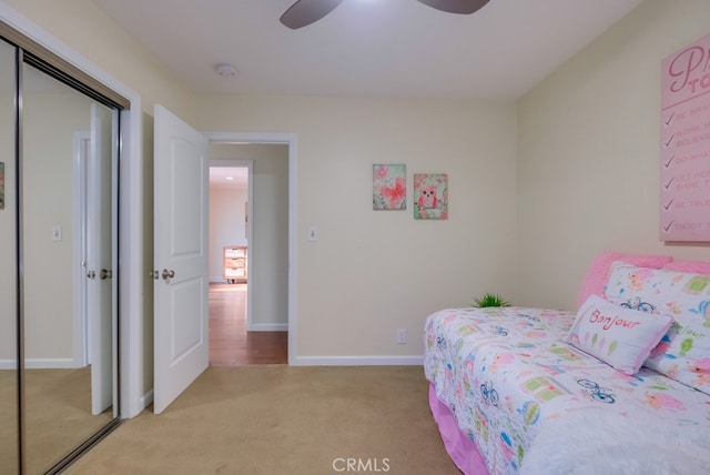 bedroom featuring a closet, light colored carpet, and ceiling fan