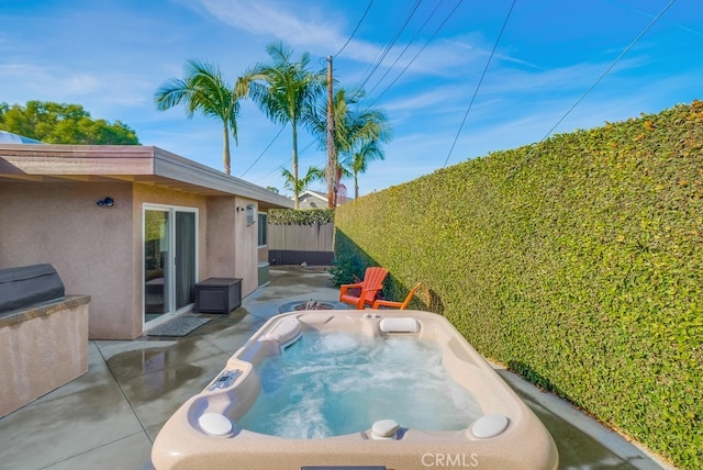 view of swimming pool featuring a hot tub and a patio