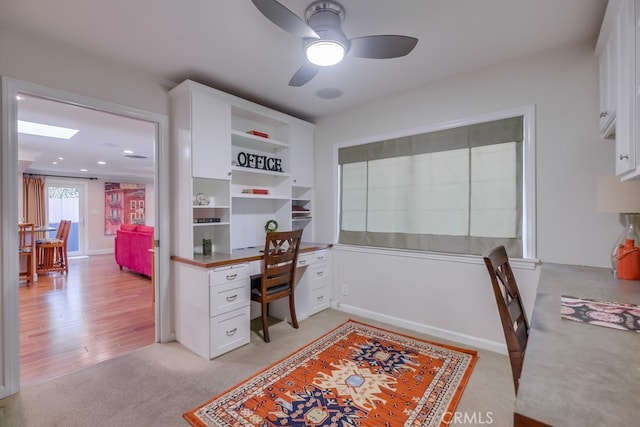 carpeted office space featuring ceiling fan