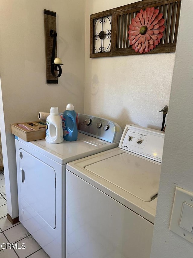 laundry area with independent washer and dryer and light tile patterned flooring